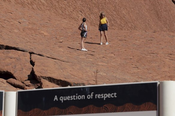 Visitors climbing up Uluru on the final day the climb is allowed.