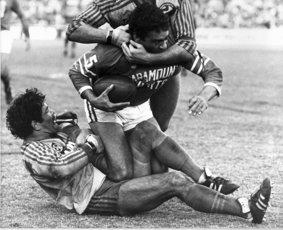 Kevin Stevens and a teammate tackle Newtown’s Ray Blacklock.