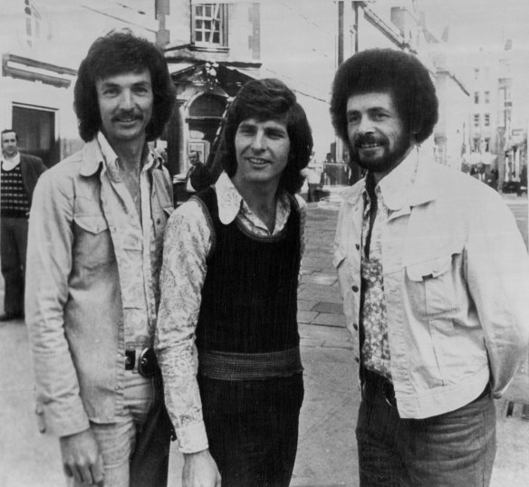 The New World pop group in London, where they were appearing at Bow St Magistrates Court on charges of uttering forged postcards. From left: Mel Noonan, 30, John Kane, 27, and John Lee, 29. June 15, 1973.


