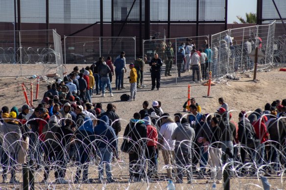 Migrants wait in line to be processed at the US-Mexico border before the lifting of Title 42