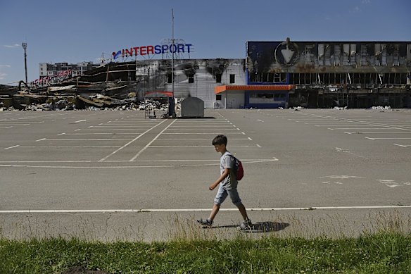 A boy passes ruined buildings in Bucha after heavy Russian shelling and missiles. 