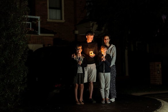 Paul and Maria Hanson and their children Tom and Jack observe a minute silence in their driveway on April 25, 2020 in Melbourne, Australia. 