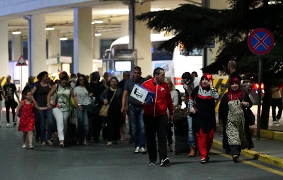 Passengers leave the Turkey's largest airport, Istanbul Ataturk, after the suicide bomb attack in Istanbul, Turkey.