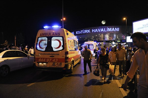 Passengers leave the Turkey's largest airport, Istanbul Ataturk after the suicide bomb attacks as ambulances enters.