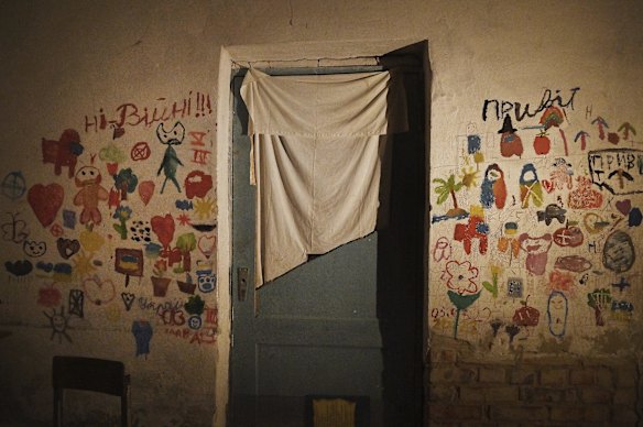 Children's drawings and messages 'No to war' (left) and 'Hello' (right) on a wall of one of the rooms in a school basement in Yahidne where 371 people from the village were held. 