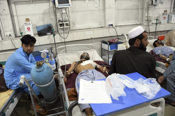 Wounded Afghans lie on a bed at a hospital after a bomb attack in the city of Jalalabad.