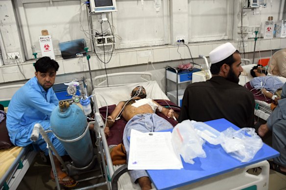 Wounded Afghans lie on a bed at a hospital after a bomb attack in the city of Jalalabad.