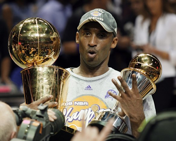 2009: Los Angeles Lakers' Kobe Bryant holds the Larry O'Brien championship trophy and finals MVP trophy after the Lakers defeated the Orlando Magic 99-86 in Game 5 of the NBA basketball finals in Orlando, Florida.