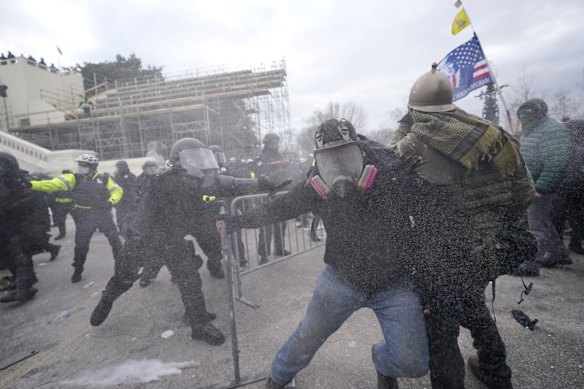 Trump supporters try to break through a police barrier at the Capitol building.
