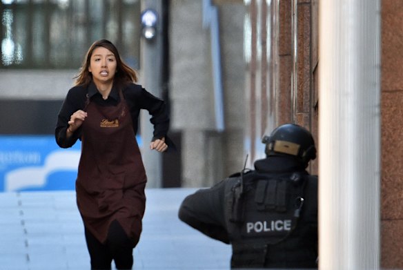 A hostage runs towards police from a the Lindt cafe.