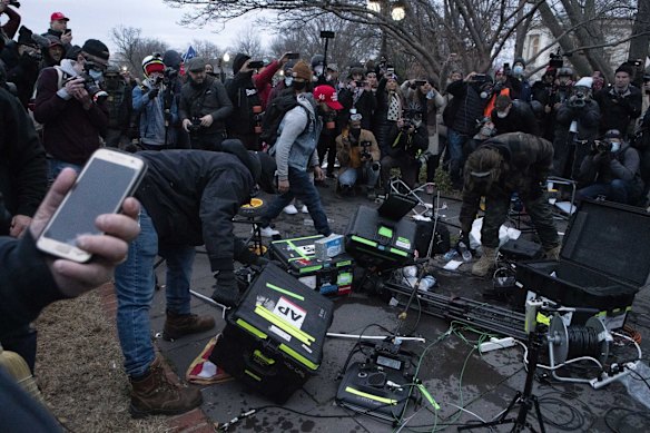 Demonstrators break TV equipment that was abandoned as the riot escalated.