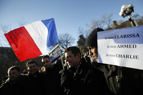 An attendee waves a French flag as several hundred people gather in solidarity with victims of two terrorist attacks in Paris, one at the office of weekly newspaper Charlie Hebdo and another at a kosher market, in New York's Washington Square Park, Saturday, Jan. 10, 2015.
