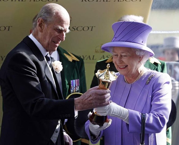 Queen Elizabeth receives the trophy from Prince Philip, Duke of Edinburgh, after her horse Estimate won The Queen's Vase at Royal Ascot.