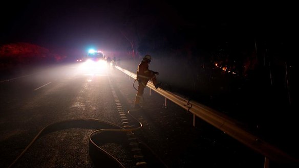 RFS fire fighter in position along the Bells Line of Road west of Mt Tomah last night as fire threatened to jump the road from ember attack.