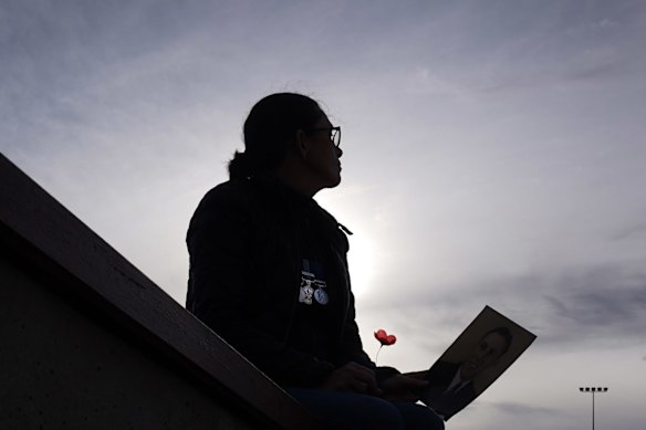 Libby Haverfield pays tribute while she holds a photograph of her father who served for the New Zealand Airforce in WWII onAnzacDay in Melbourne, Saturday, April 25, 2019. 