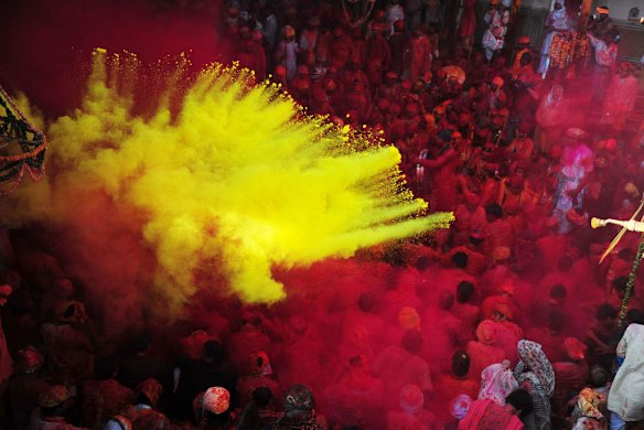 Indian Hindu devotees throw coloured powder at the Radha Rani temple in Barsana, India.