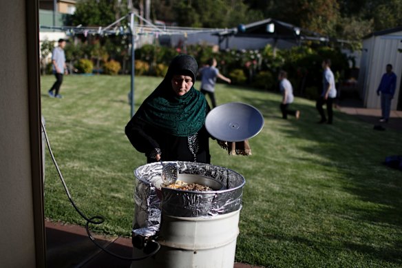 Kurvangul Tursun cooks lamb pilaf in the backyard of her home in Adelaide.