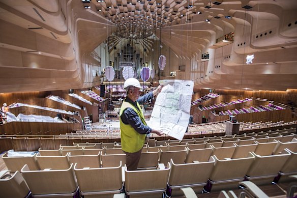 Plans with the seating layout of approx. 4000 seats, being looked over by Project Manager of chair install, Tony Cocks.