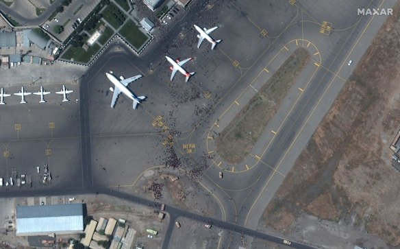 This satellite photo from Maxar Technologies shows swarms of people on the tarmac at Kabul International Airport, also known as Hamid Karzai International Airport. Afghans rushed onto the tarmac of the capital's airport on Monday as thousands tried to flee the country after the Taliban seized power with stunning speed. Some clung to the side of a U.S. military transport plane before takeoff, in a widely shared video that captured the sense of desperation as America's 20-year war comes to a chaotic end. 