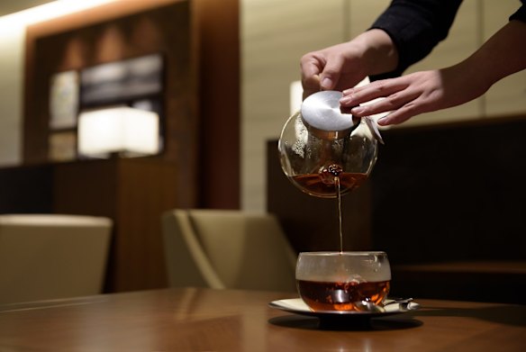 An employee serves tea to a customer at the View Gold Lounge, operated by East Japan Railway Company and View Card, at Tokyo Station in Tokyo, Japan. Passengers on the GranClass can check into this lounge at Tokyo Station before boarding.