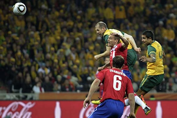 Australia's Tim Cahill, right, heads the ball to score a goal.