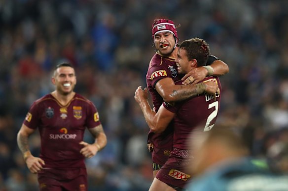 Johnathan Thurston of the Maroons celebrates with team mate Corey Oates after winning game one.