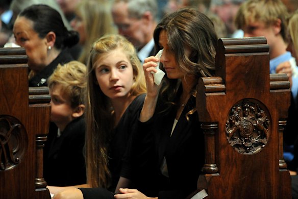 Jim's wife Sam wipes a tear during the mass as her daughter Matisse and son Tiernan sit by her side.