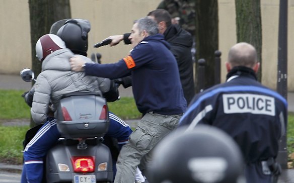 French police arrest young people on a scooter as they arrive near the scene of a hostage taking at a kosher supermarket in eastern Paris. 