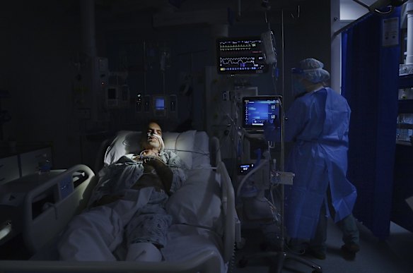 Senior ICU Registered Nurse Gabby McLoughlin (right) cares for a COVID-19 positive patient at St Vincent's Hospital.