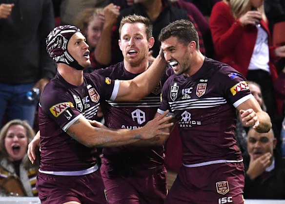 Corey Oates of the Maroons celebrates scoring a try with teammates.