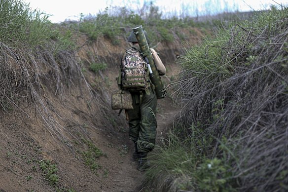 A serviceman of the Donetsk People's Republic militia walks along a trench near one of the frontlines outside Vasylivka village in Yasynuvata district, which is under the government of the Donetsk People's Republic, in eastern Ukraine.
