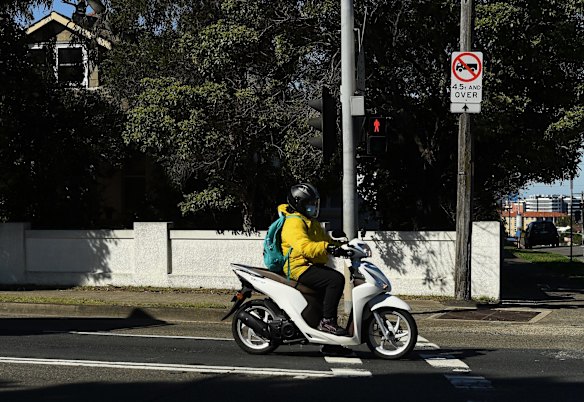 A person on a scooter waits at traffic lights in Bexley during the COVID-19 lockdown, in the Bayside LGA which is under additional restrictions.