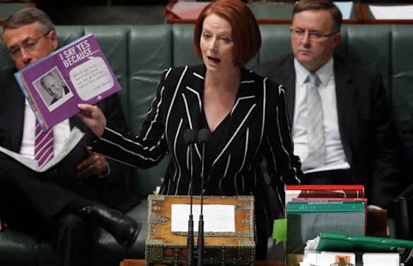Prime Minister Julia Gillard holds up a document during question time yesterday.