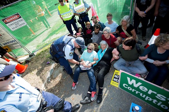 Westconnex protestors link arms and stage a sit-in before being forceably removed in an effort to block logging crews preparing to fell trees in the wake of the proposed motorway at Sydney Park in St. Peters.