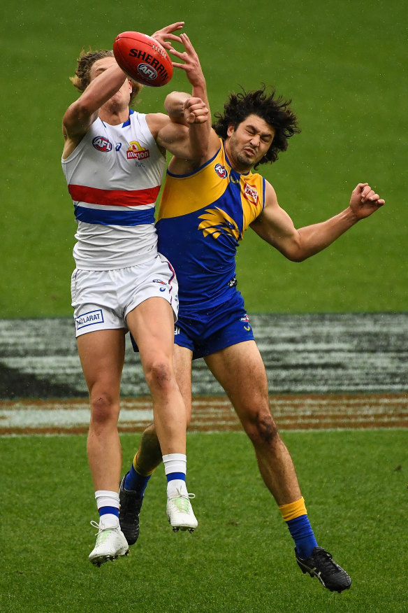 Tom Barrass from the Eagles and Dogs forward Aaron Naughton compete for a mark.