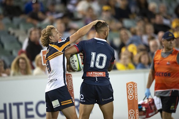 The Brumbies' Joe Powell and the Rebels' Quade Cooper muss up each other's hair as they fight for the ball after it had gone into touch.  