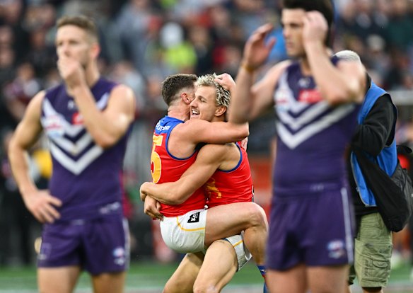 What a contrast: The Lions celebrate, while the Dockers were in disbelief after a meltdown for the ages late in the grand final.