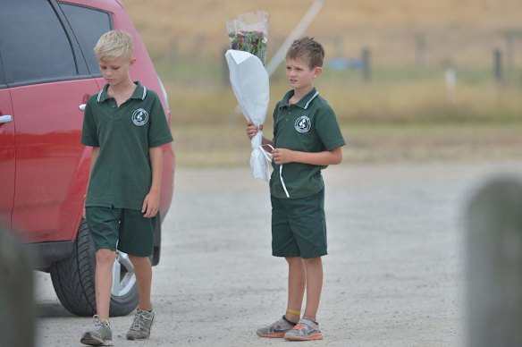 Friends arrive at the Tyabb oval to place flowers.