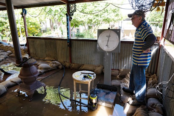 Dick Sharkey uses a pump to try to stop rising flood water entering his home, Friday November 4, 2022.
