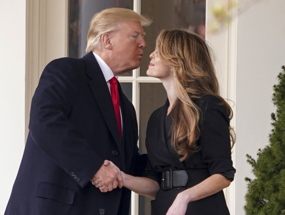 US President Donald Trump kisses White House communications director Hope Hicks on her last day on Friday.