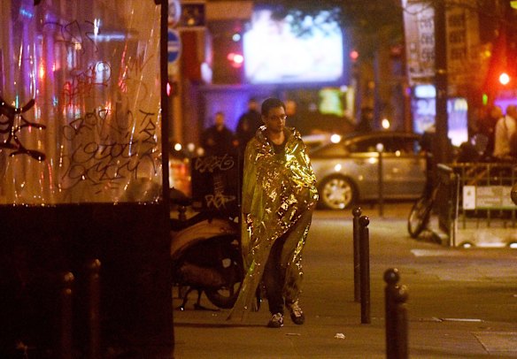 A survivor walks in the street after surviving the Bataclan concert hall terror incident.