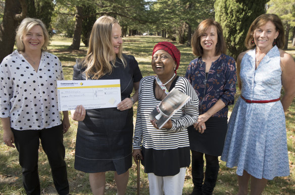 Singed Sisters Karen Downing, Chandani Prammer, Liz Tilley and Julie Pham, donate the proceeds of their cookbook to the YWCA through executive director Frances Crimmins. 