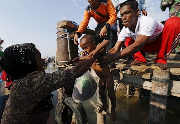 A Rohingya mother, who arrived by boat, hands her child to a volunteer at the port of Julok village in Kuta Binje, Indonesia's Aceh Province, May 20, 2015. Hundreds of Rohingya and Bangladeshi migrants landed in Indonesia's northwestern Aceh province early on Wednesday, an Indonesian search and rescue official said. 

