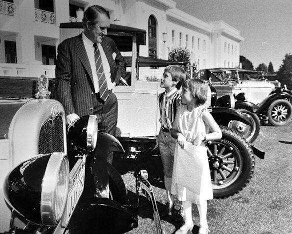 Former Prime Minister Malcolm Fraser chats with Craig and Fiona Davidson as he looks over some of the veteran and vintage cars gathered at Parliament House for as rally.(2/4/80)