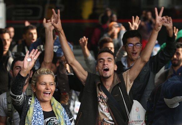 Migrants arriving with approximately 800 others on a train from Hungary react to the welcoming cheers of onlookers at Munich Hauptbahnhof main railway station in Munich, Germany. 