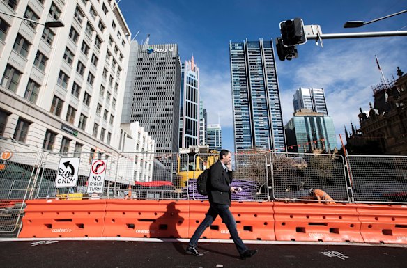 A man walks past the construction of the light rail at the intersection of George Street and PArk Street, Sydney.