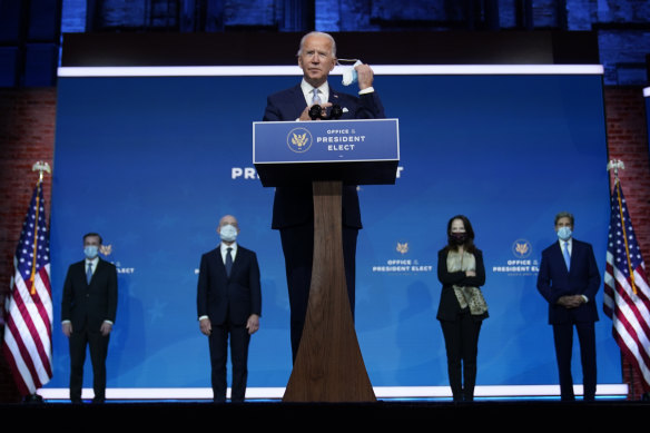 Joe Biden removes his mask to introduce his national security and foreign policy team.