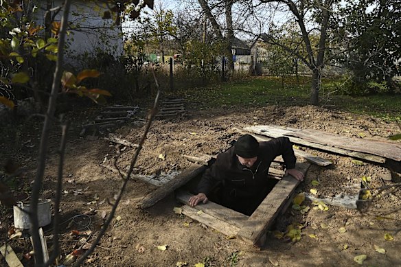 Oleksandr, 54, climbs out of the bomb shelter that his son has built in the yard of his home in Novooleksandrivka village in the Kherson Oblast. The windows in his home shattered from the impact of a Grad missile hitting the street outside his home on October 14. 