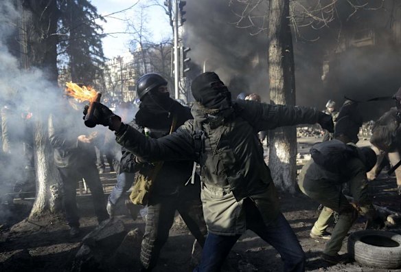 An anti-government protester throws a Molotov cocktail towards Interior Ministry members during clashes in Kiev, February 18, 2014. Several thousand anti-government protesters clashed with police near Ukraine's parliament on Tuesday, torching vehicles and hurling stones in the worst violence to rock the capital Kiev in more than three weeks.