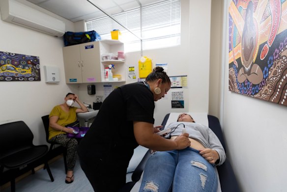 Mel Briggs checks for Maria Coslovich's baby's heartbeat, whilst her mother, Marlane Reay, looks on, at Waminda.